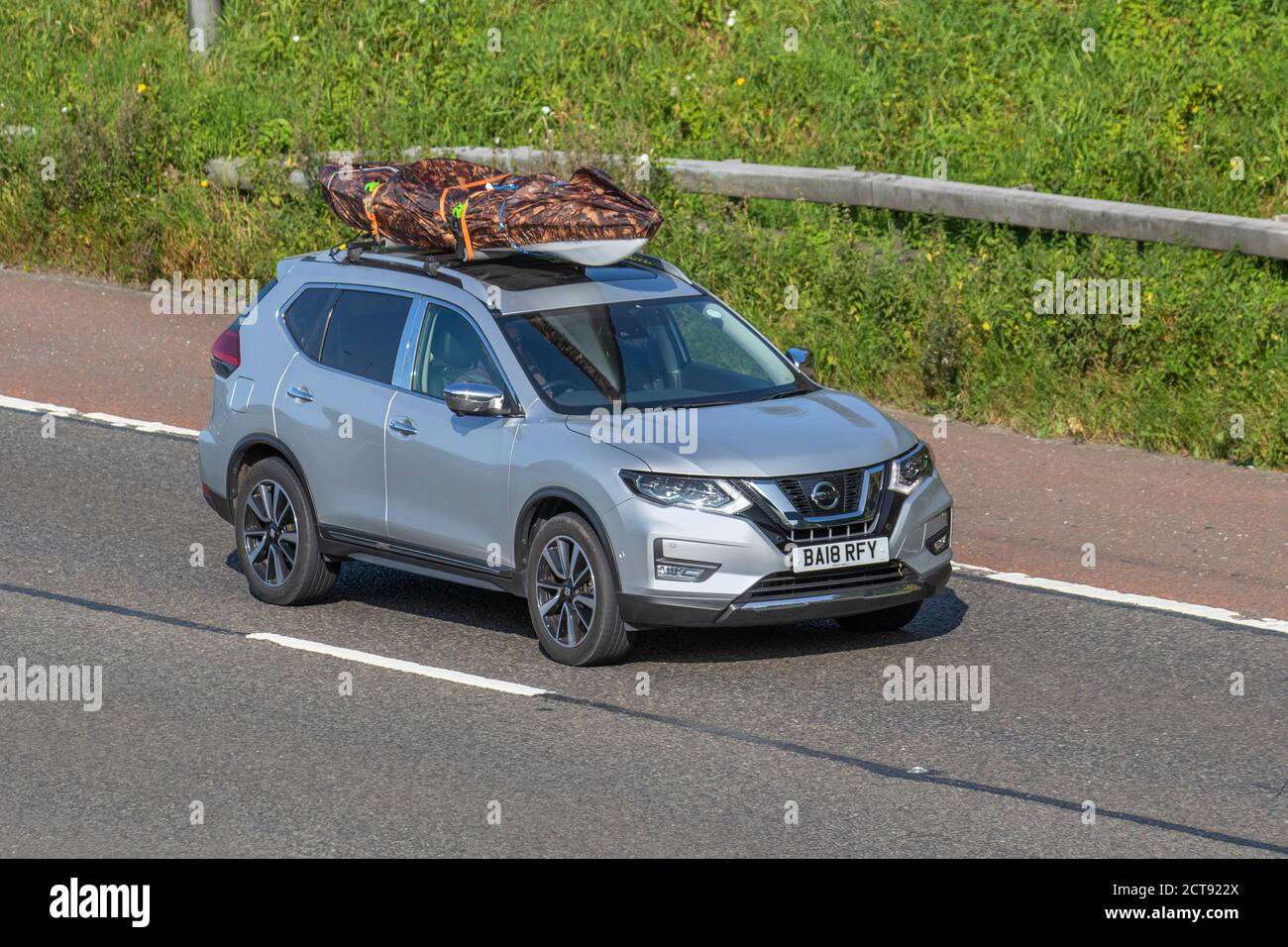 2018 Nissan X-Trail Tekna DCI 4X4 CVT with covered canoe or kayak on roof rack; Vehicular traffic moving vehicles, cars driving vehicle on UK roads, motors, motoring on the M6 motorway highway network. Stock Photo