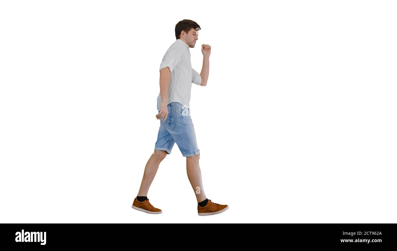 Young man in casual clothes dancing happily while walking on whi Stock Photo