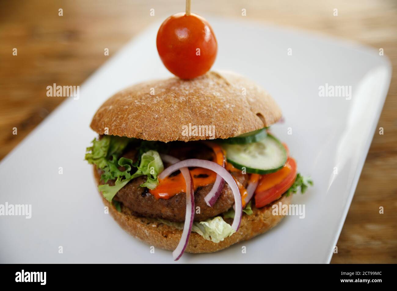 A burger isolated on a white plate with negative space. Stock Photo