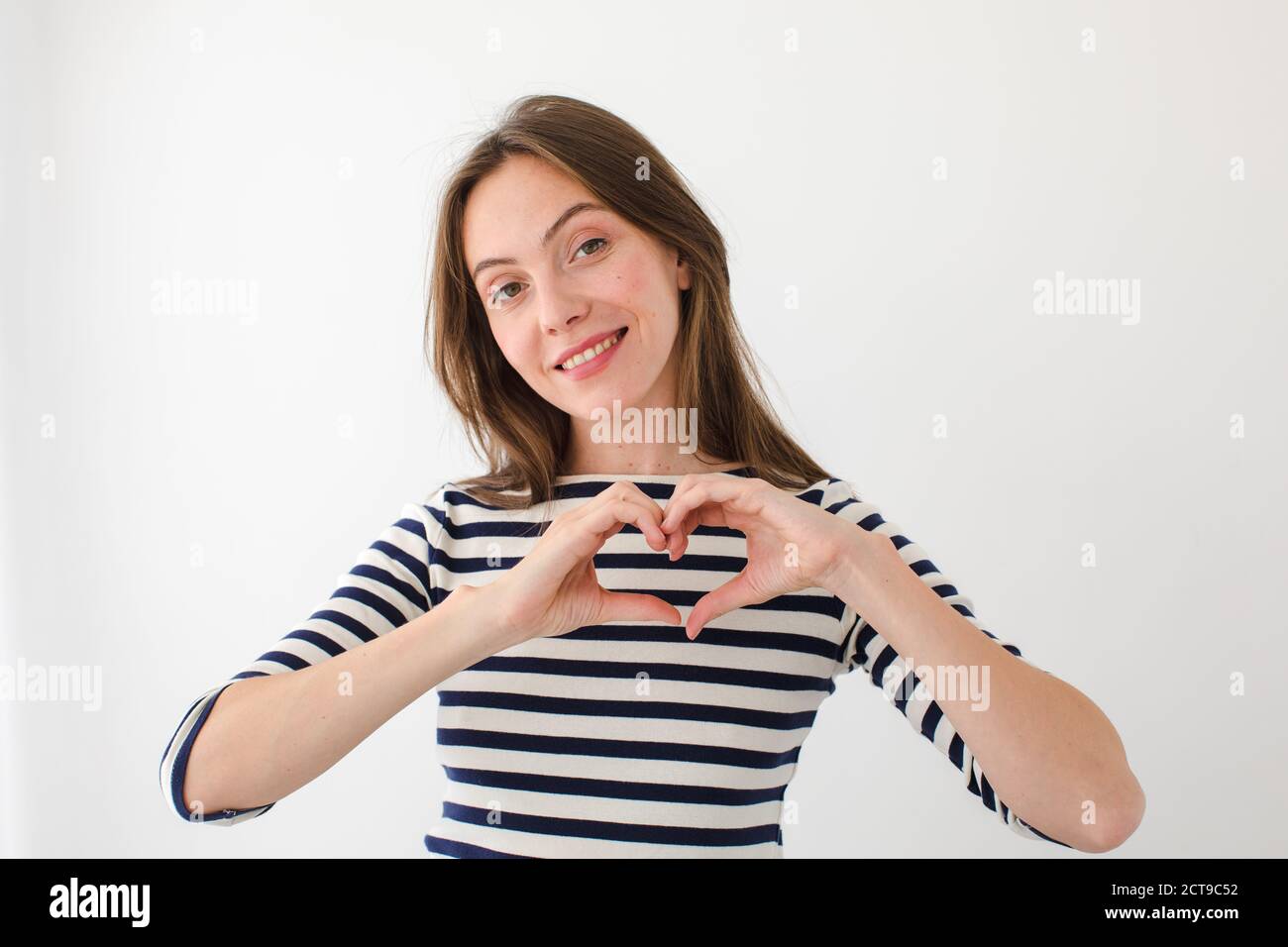 Charming woman showing heart gesture Stock Photo