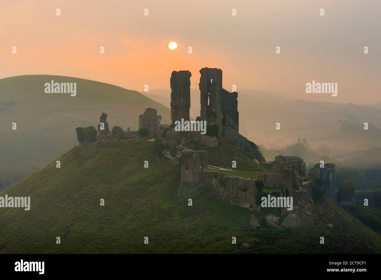 Corfe Castle, Dorset, UK.  22nd September 2020.  UK Weather.  A misty sunrise at Corfe Castle in Dorset with the rising sun obscured by misty low cloud on the autumn solstice.  Picture Credit: Graham Hunt/Alamy Live News Stock Photo