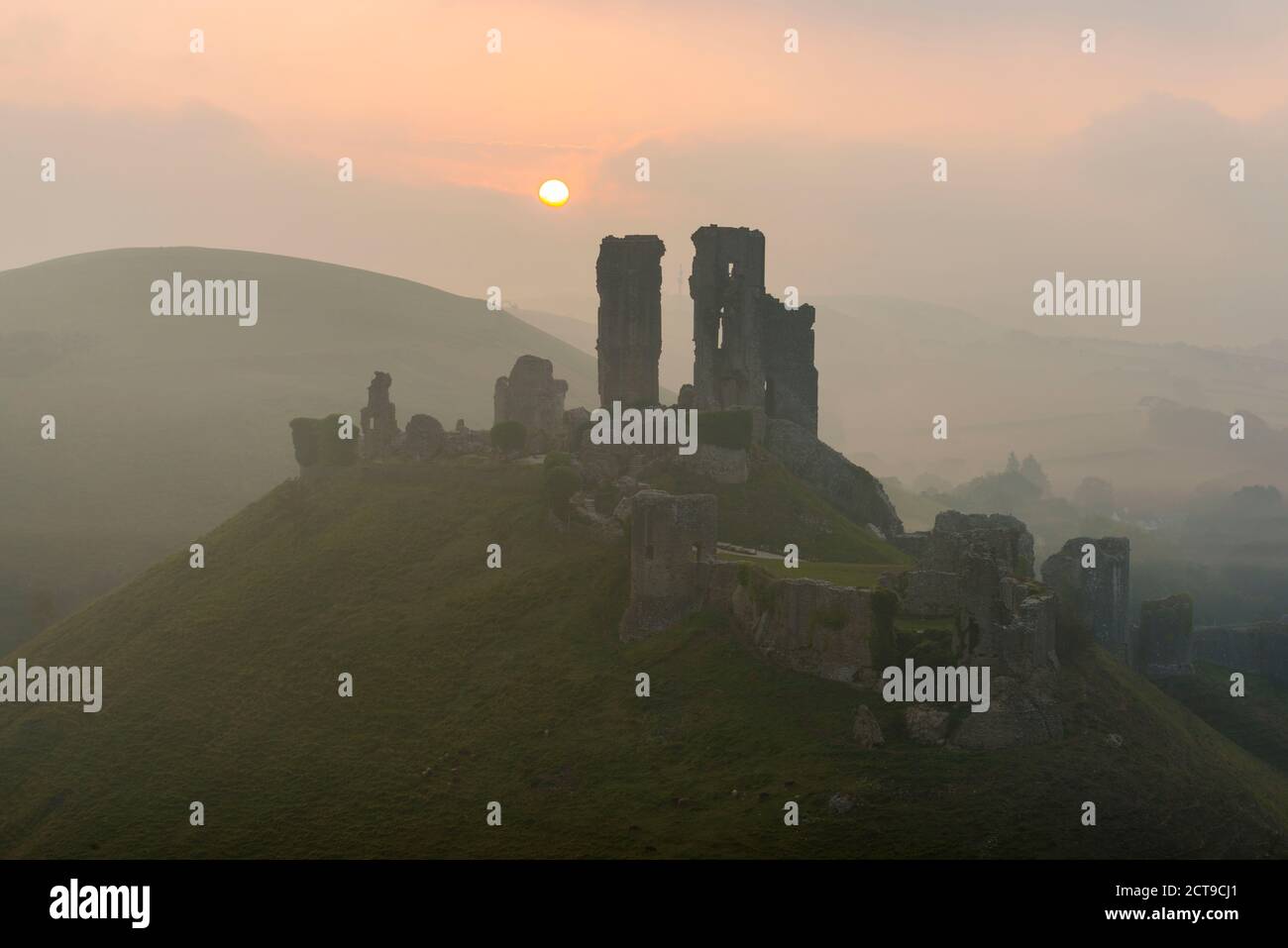 Corfe Castle, Dorset, UK.  22nd September 2020.  UK Weather.  A misty sunrise at Corfe Castle in Dorset with the rising sun obscured by misty low cloud on the autumn solstice.  Picture Credit: Graham Hunt/Alamy Live News Stock Photo