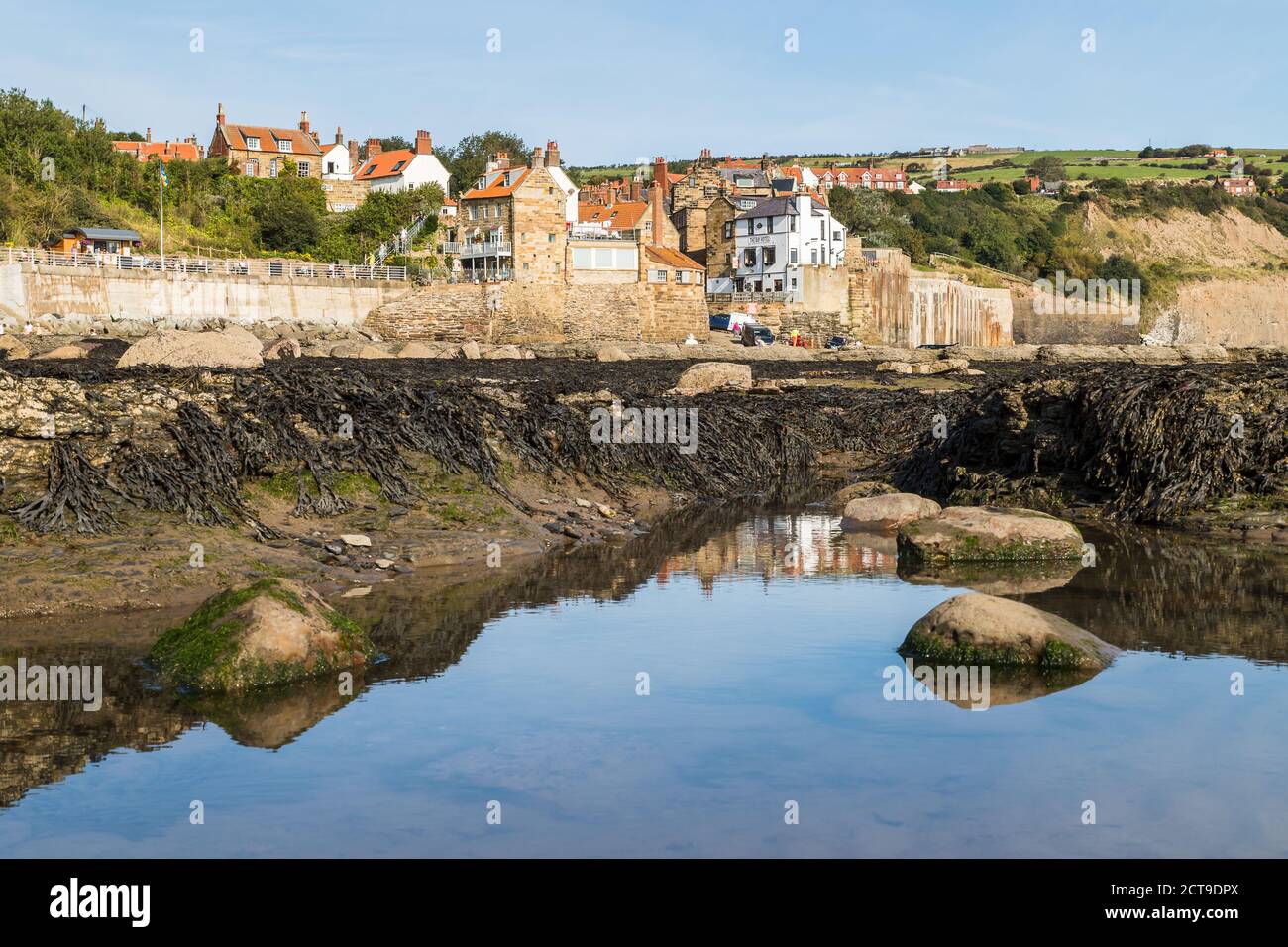 Rockpools in front of Robin Hoods Bay seen on a bright and calm morning in September 2020 on the North Yorkshire coast. Stock Photo