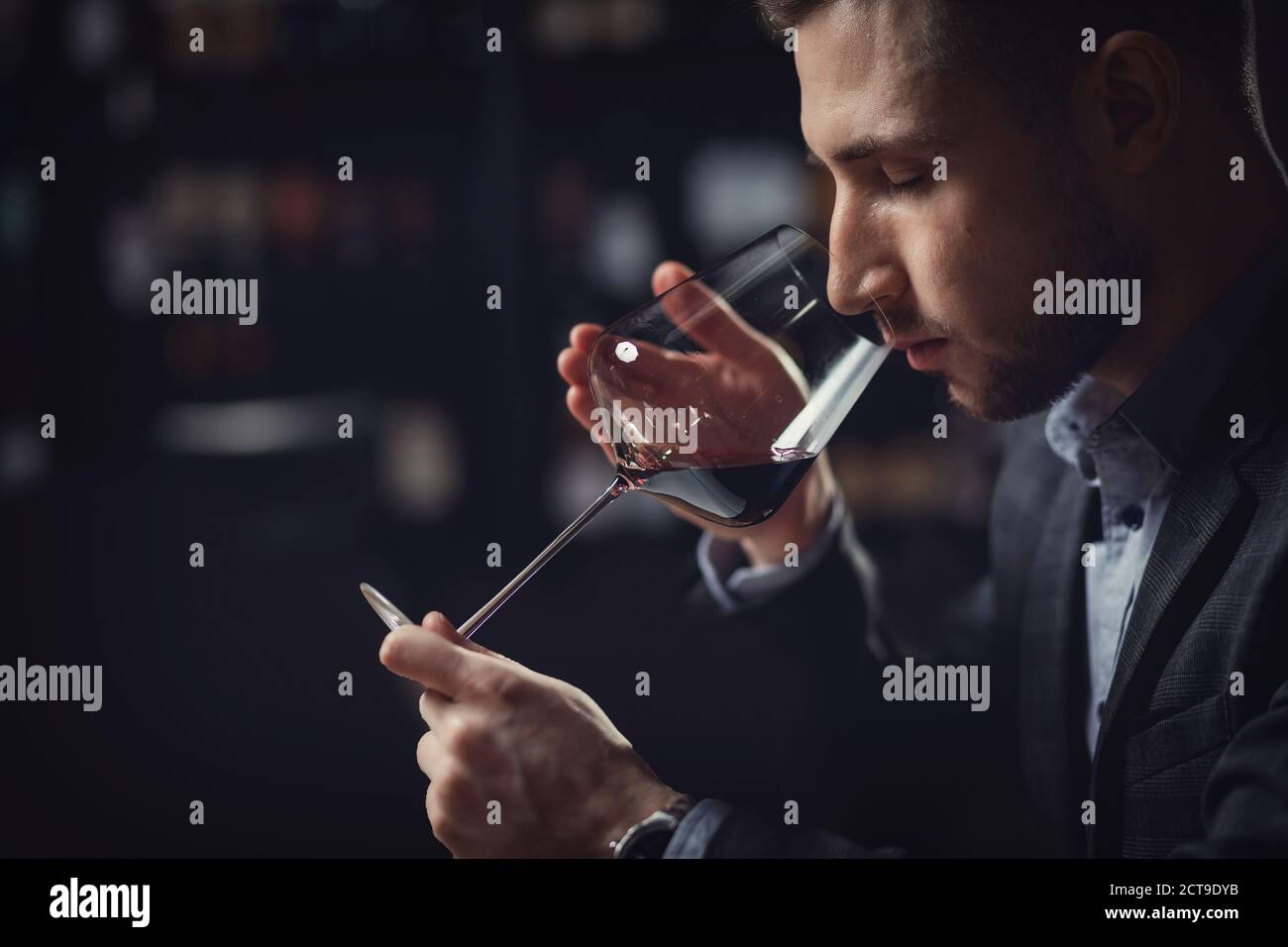 Sommeliers male hold glass red wine tasting degustation card Stock