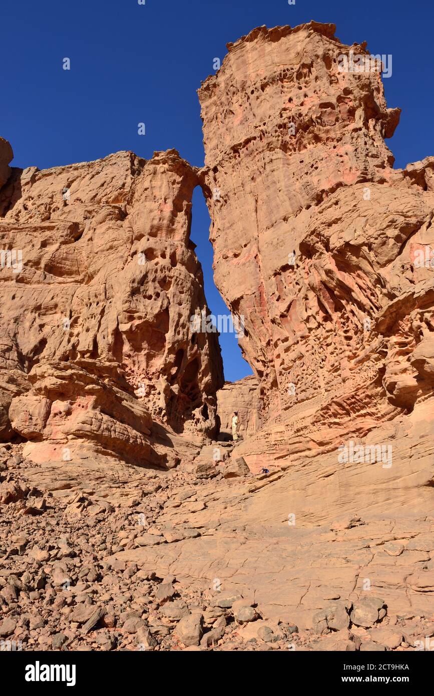 Algeria, Sahara, Tassili N'Ajjer National Park, Tassili Tadrart, woman hiking in the rocky landscape of the cirque Stock Photo