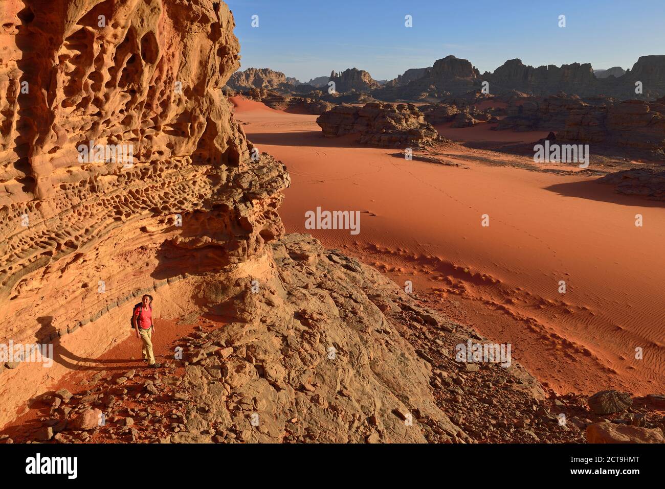 Algeria, Sahara, Tassili N'Ajjer National Park, Tassili Tadrart, woman hiking in the rocky landscape of the cirque Stock Photo
