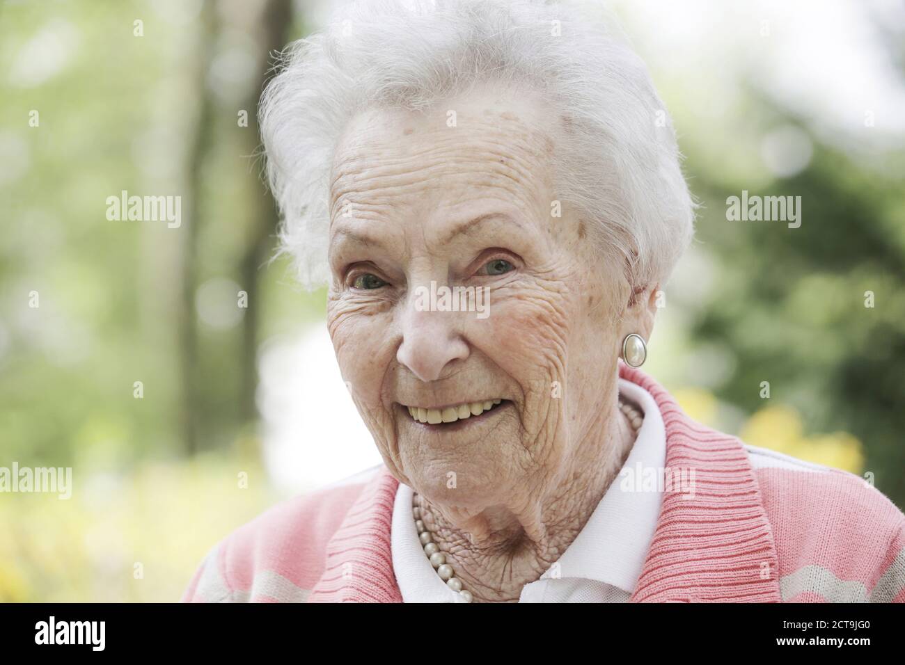 Germany, North Rhine Westphalia, Cologne, Portrait of senior woman, smiling, close up Stock Photo