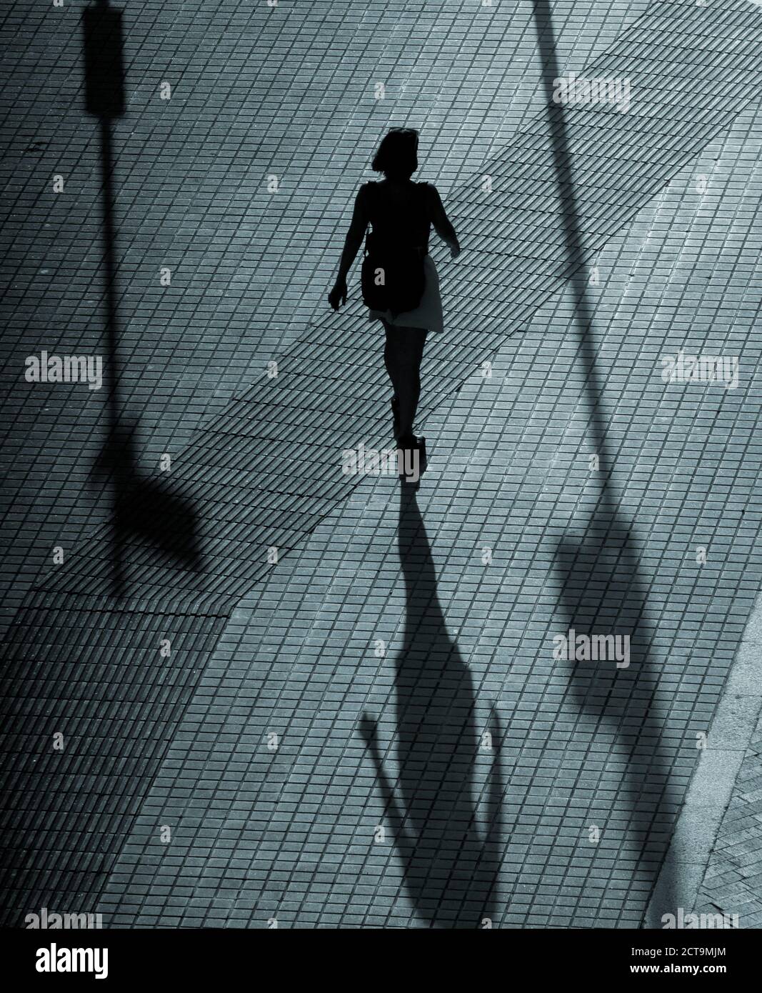 Silhouette of a woman walking in a street at night Stock Photo - Alamy