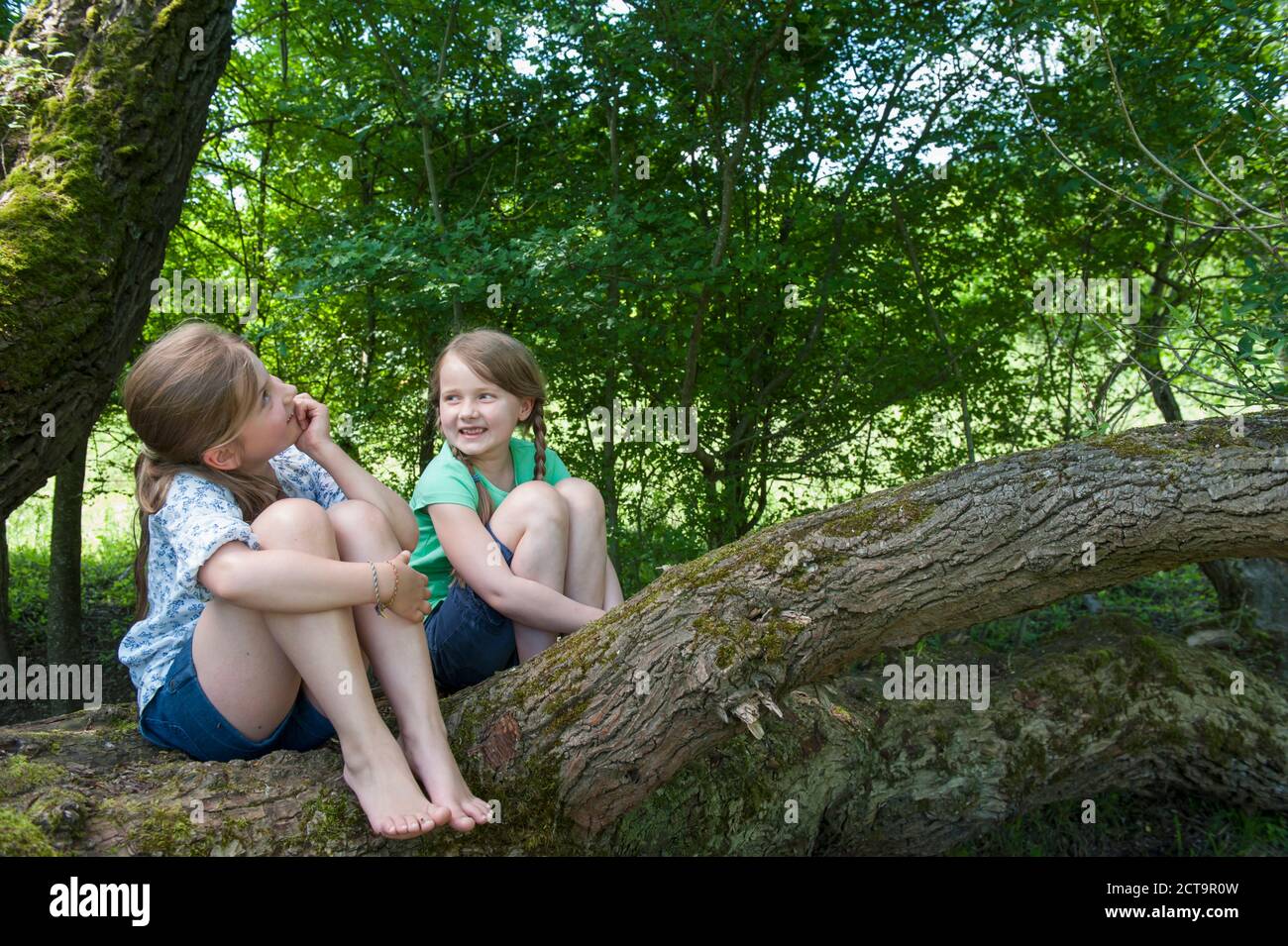 Girl sitting knees up smiling hi-res stock photography and images - Alamy