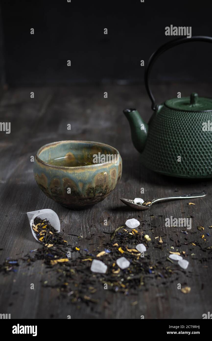 Japanese tea pot and bowl with tea leaves on wooden table, studio shot Stock Photo