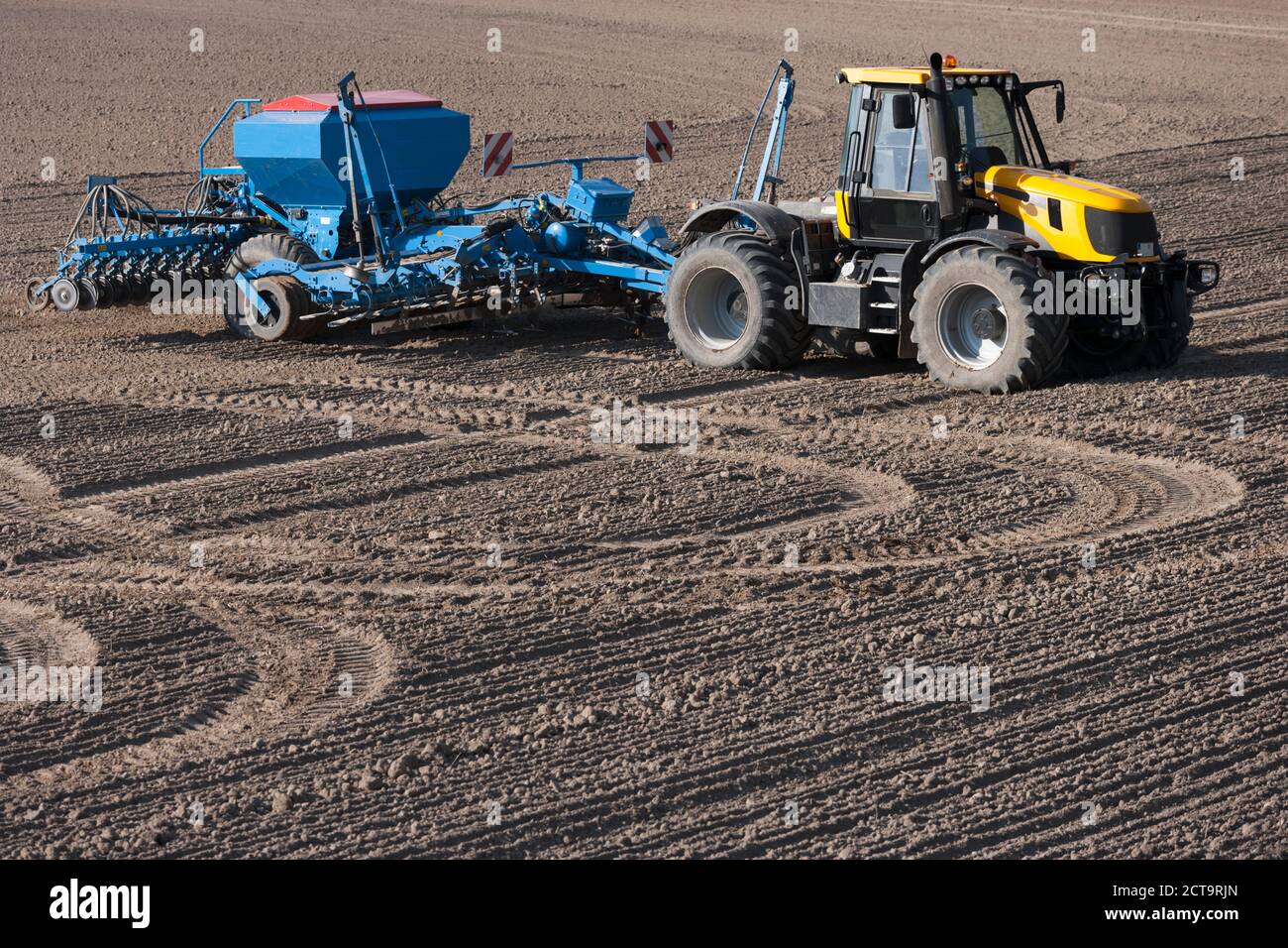 Germany, Bavaria, tractor with disc harrow on ploughed soil Stock Photo