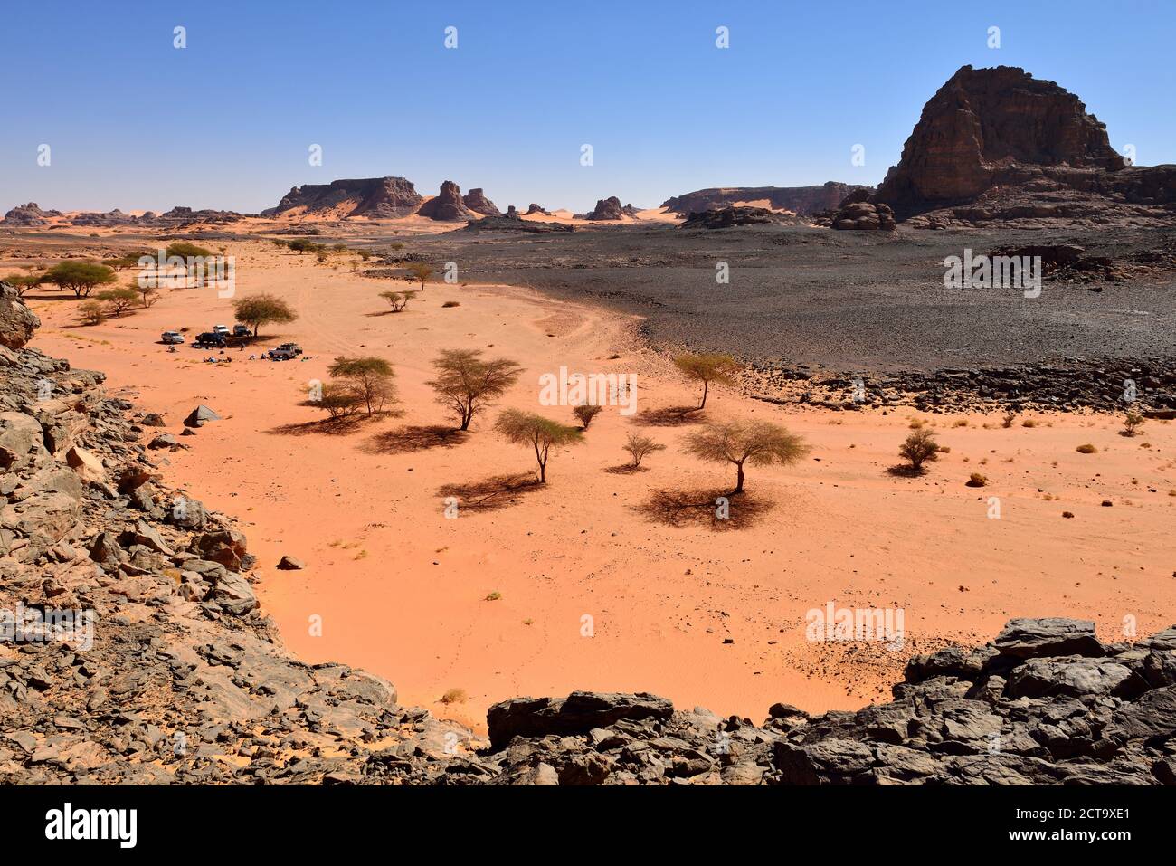 Algeria, Sahara, Tassili N'Ajjer National Park, group of tourists resting in a dry rocky valley Stock Photo