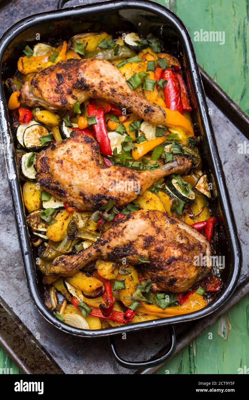 Chicken legs on mediterranean vegetables in roasting tray Stock Photo