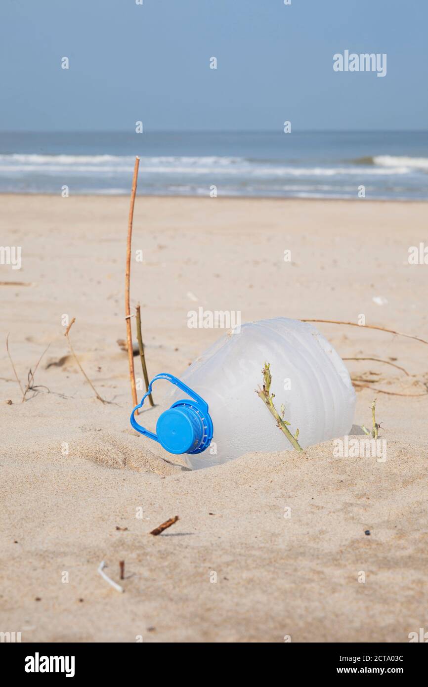 Belgium, empty plastic bottle lying on sandy beach at North Sea coast Stock Photo