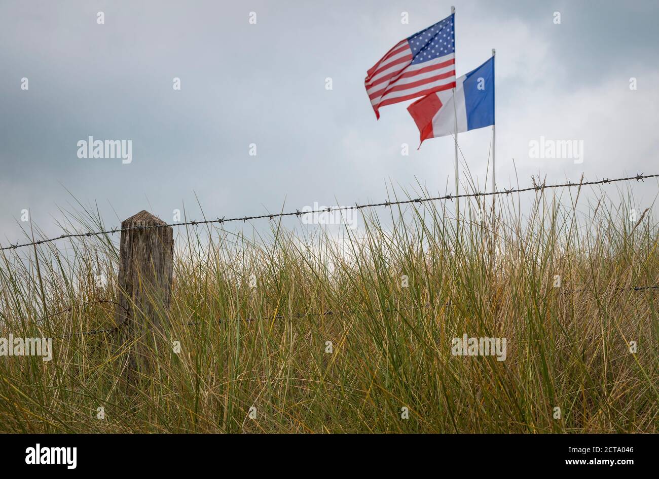 France, Lower Normandy, Manche, Sainte Marie du Mont, Utah Beach, Barbed wire fence and French and US flag Stock Photo