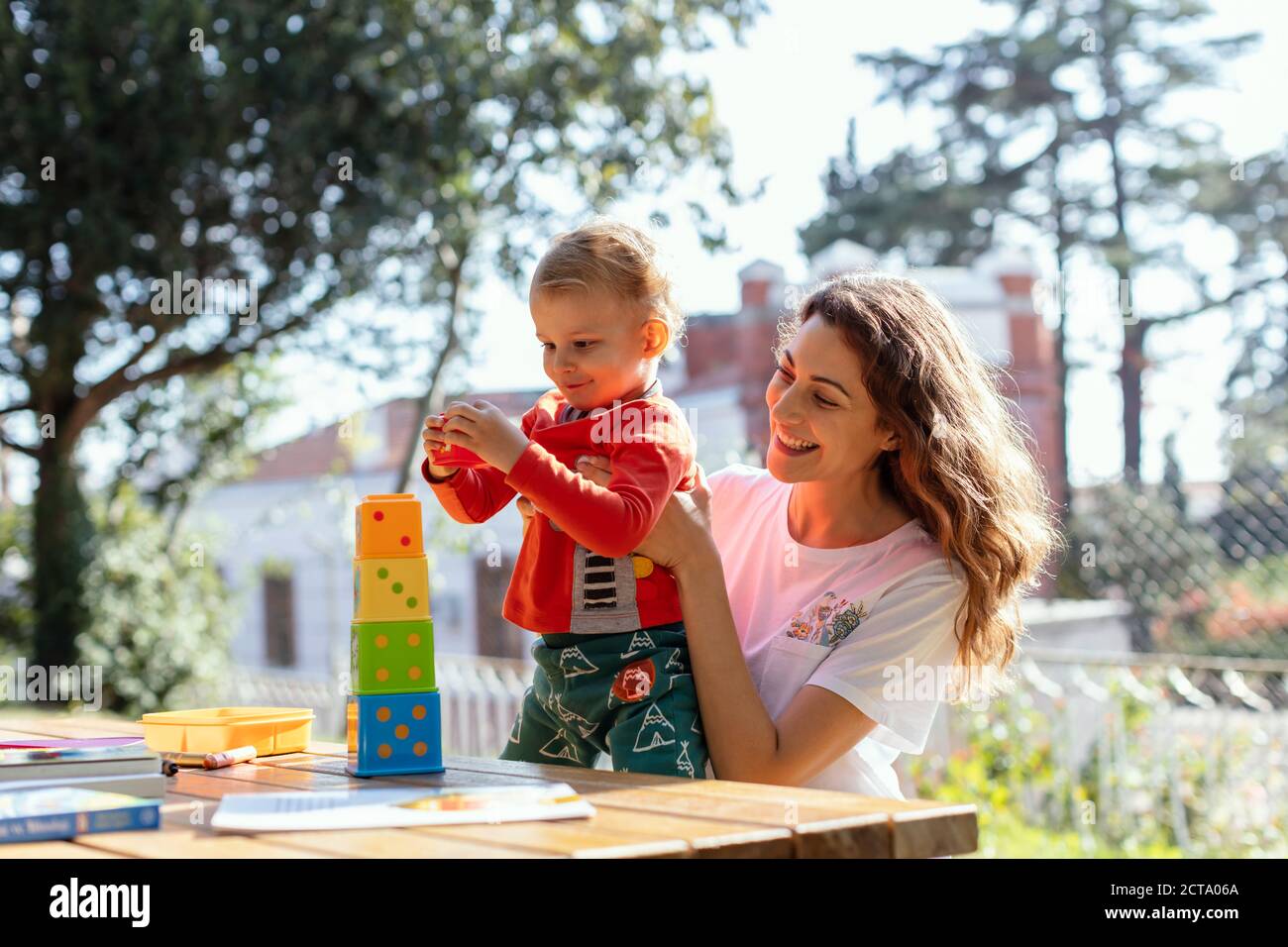 A Sunny Day ,Young Woman and Son  Playing Educational Cube  Toys at Garden Stock Photo