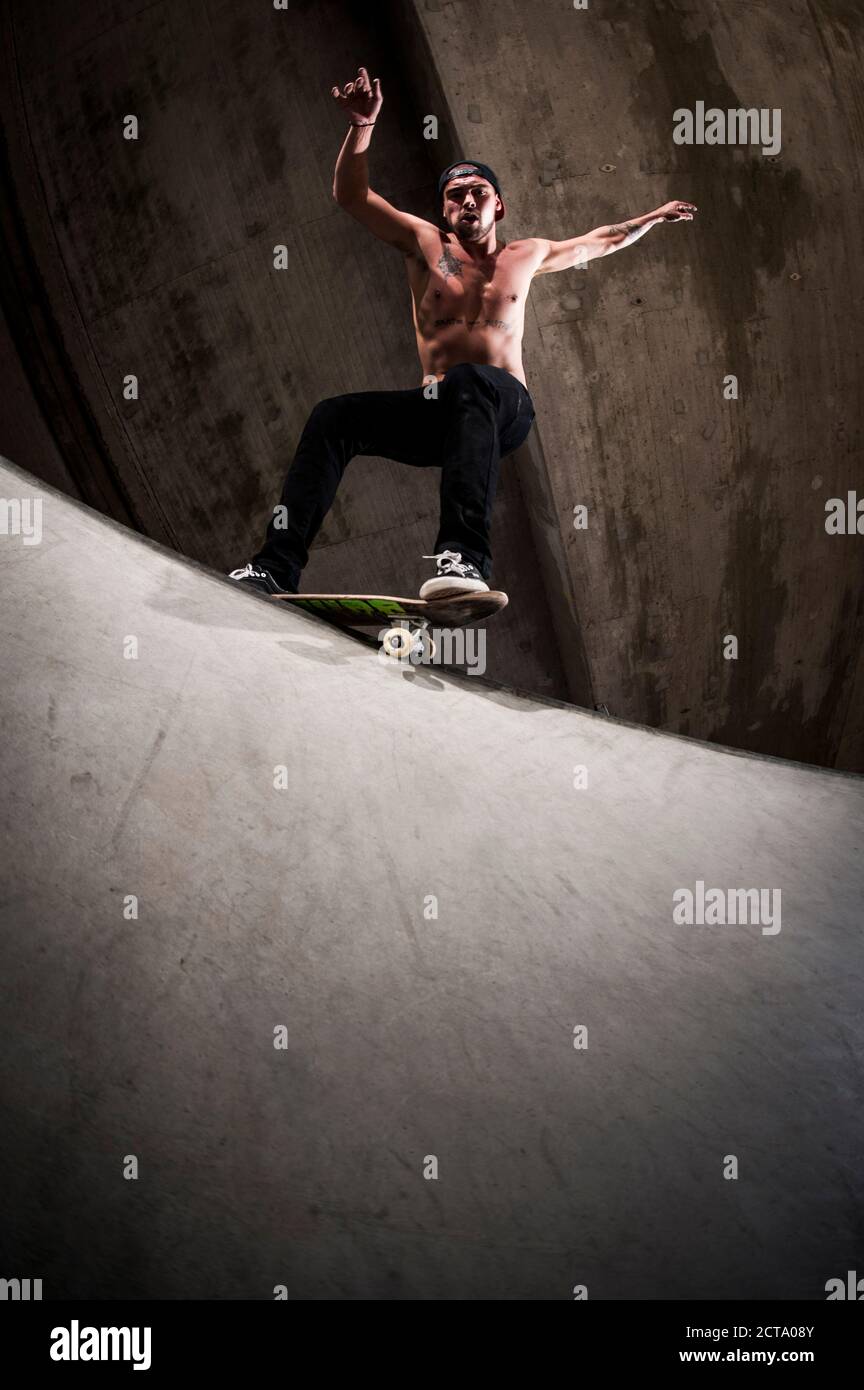 Skateboarder performing trick at skateboard park Stock Photo