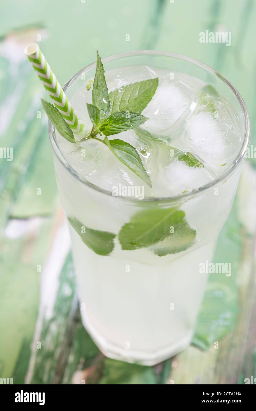 Cold drink with ice, mint and drinking straw, close up Stock Photo