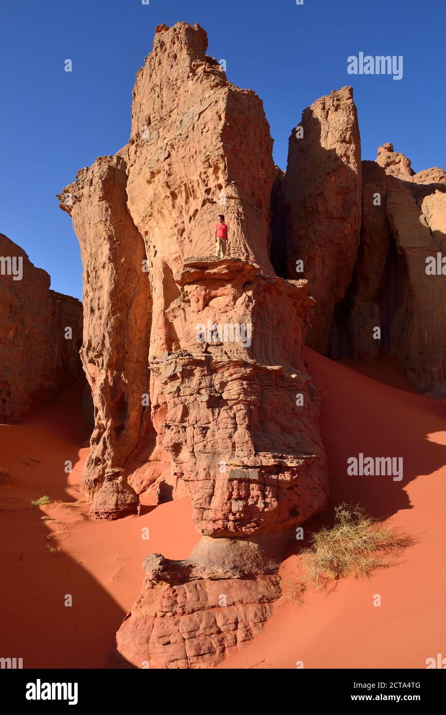 Algeria, Sahara, Tassili N'Ajjer National Park, Tassili Tadrart, woman hiking in the rocky landscape of the cirque Stock Photo