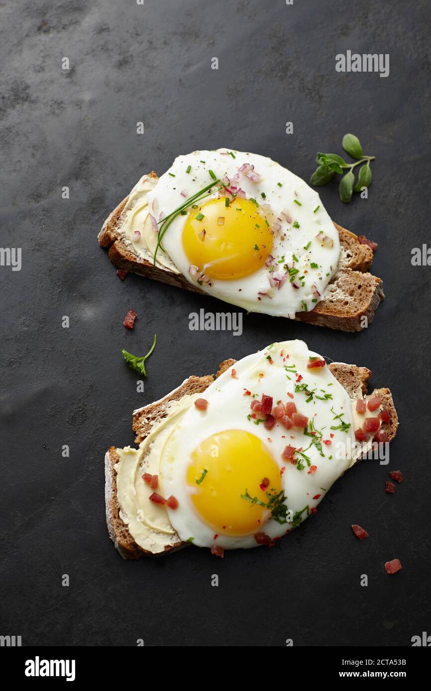 Fried egg, chives, bacon and bread Stock Photo