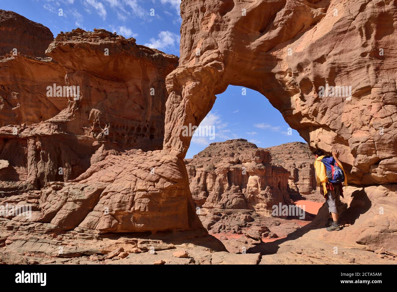 Africa, Algeria, Sahara, Tassili N'Ajjer National Park, Tassili Tadrart,  Cirque, Woman looking through a natural arch Stock Photo