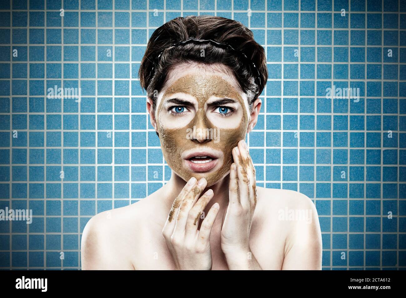 Portrait of young woman with medicinal clay mask, close up Stock Photo