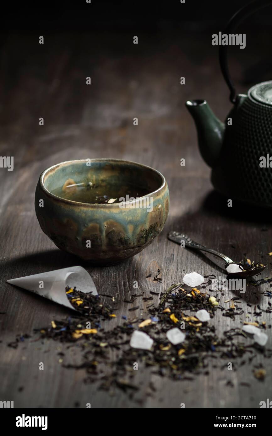 Japanese tea pot and bowl with tea leaves on wooden table, studio shot Stock Photo