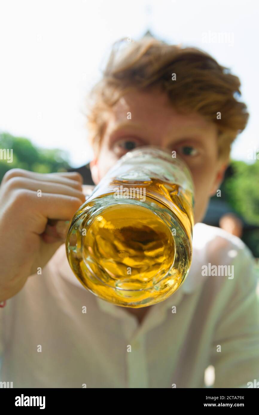Young man drinking beer outdoors Stock Photo