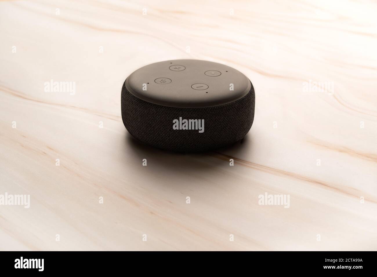 LONDON, UNITED KINGDOM - SEPTEMBER 20 2020: Close-up of an Amazon Echo Dot, the virtual assistant speaker, with a modern light marble background. Stock Photo