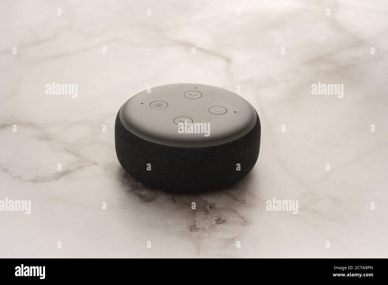 LONDON, UNITED KINGDOM - SEPTEMBER 20 2020: Close-up of an Amazon Echo Dot, the virtual assistant speaker, with a light marble effect background. Stock Photo