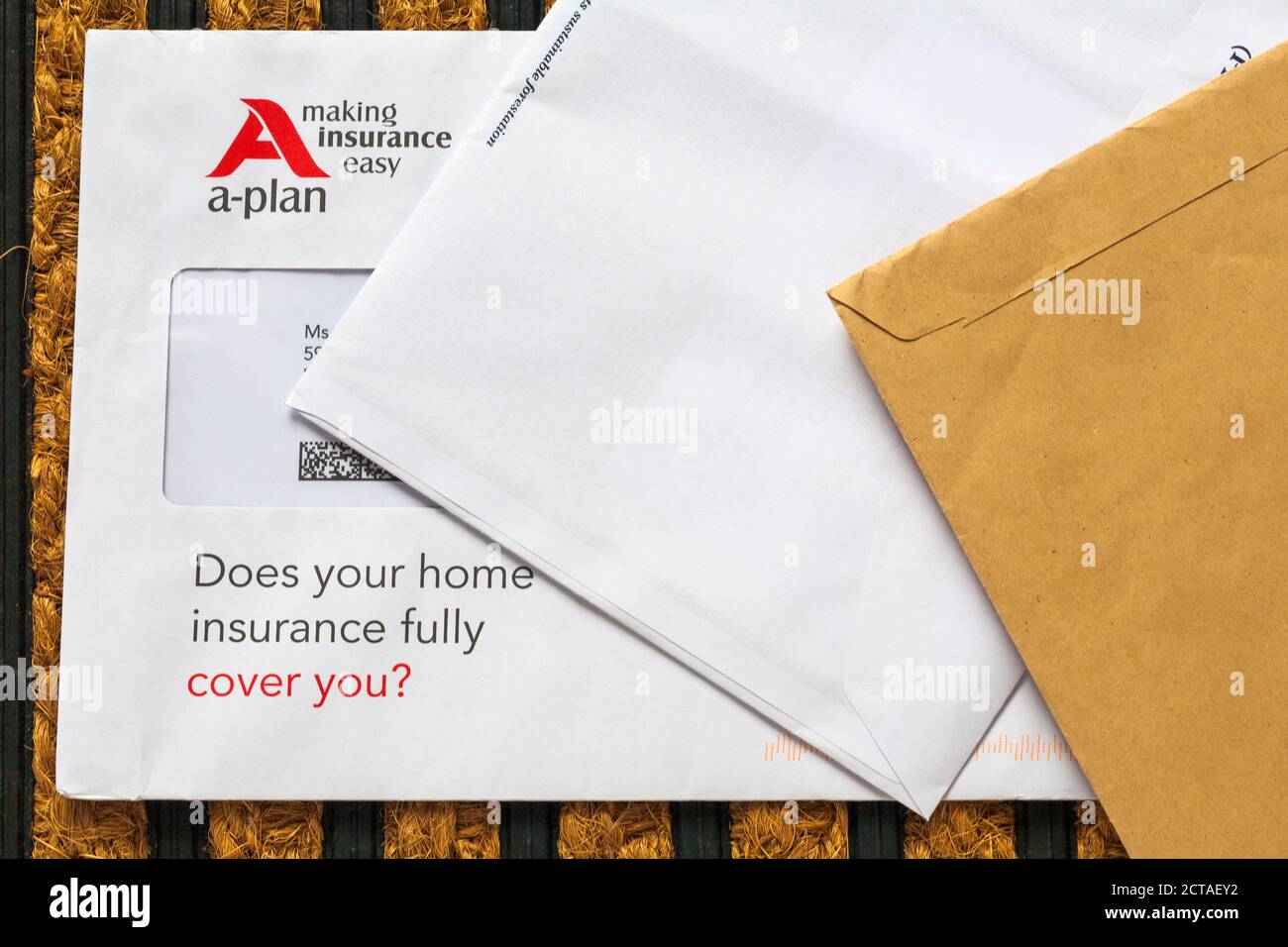 unsolicited mail junk mail on doormat - A-plan making insurance easy, does your home insurance fully cover you? Stock Photo