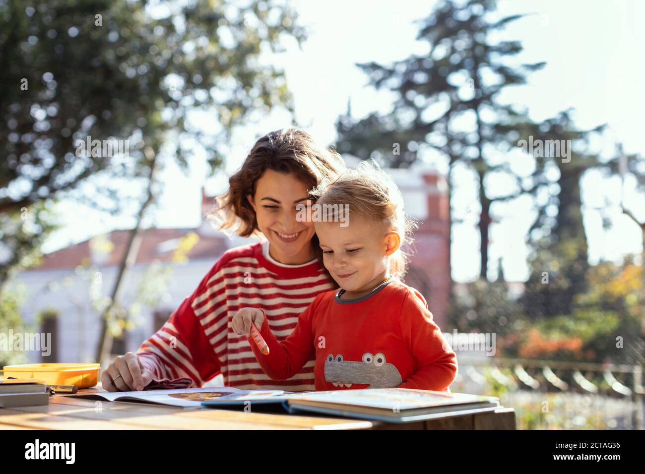Sunny Day ,Mother and Son Making Drawings in the Garden on the Picnic Table Stock Photo