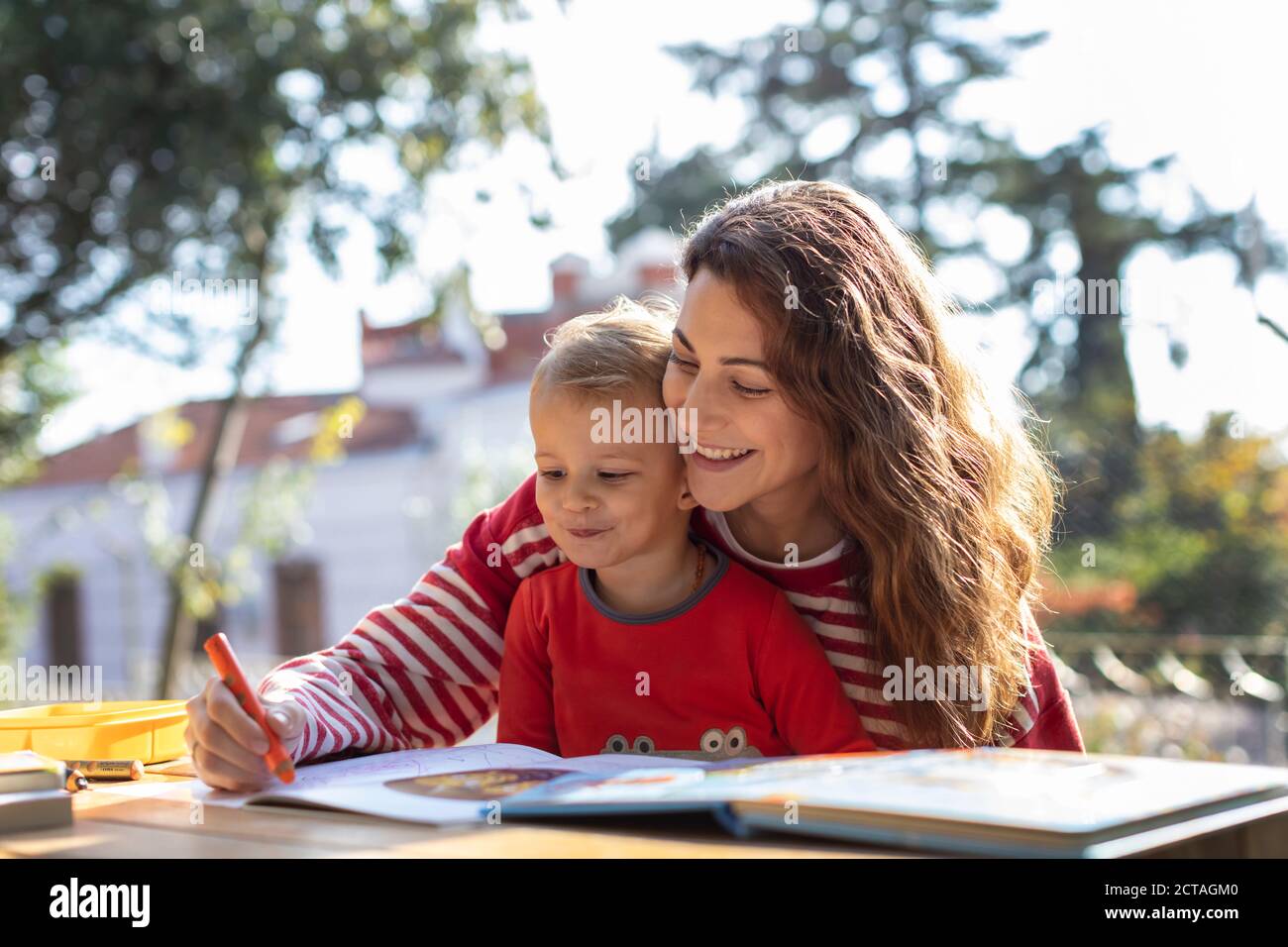 Sunny Day ,Mother and Son Making Drawings in the Garden on the Picnic Table Stock Photo