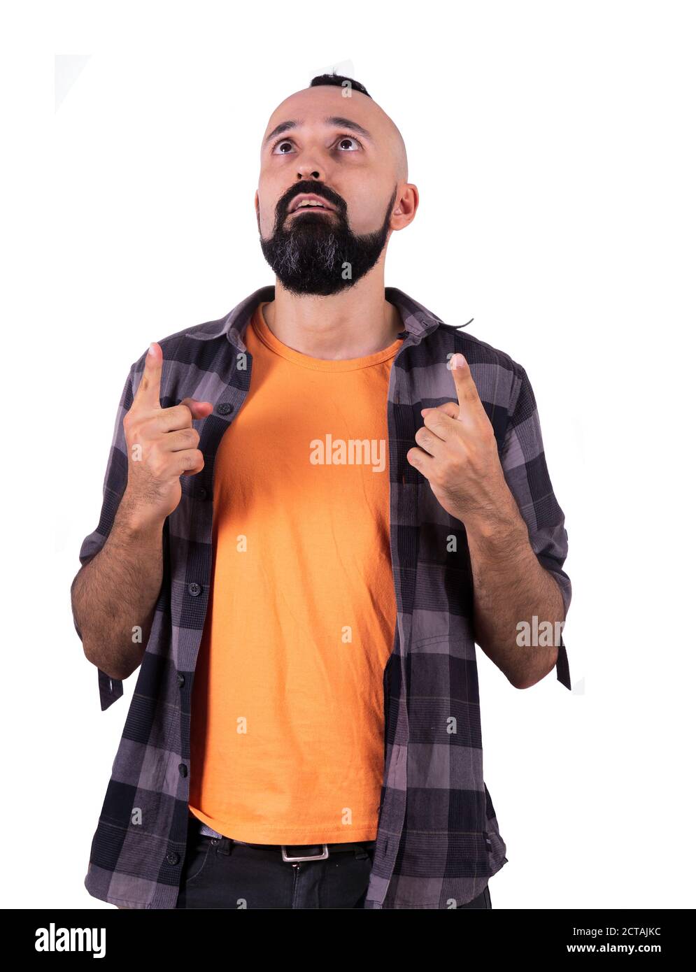 Surprised young hispanic man pointing and looking up Stock Photo