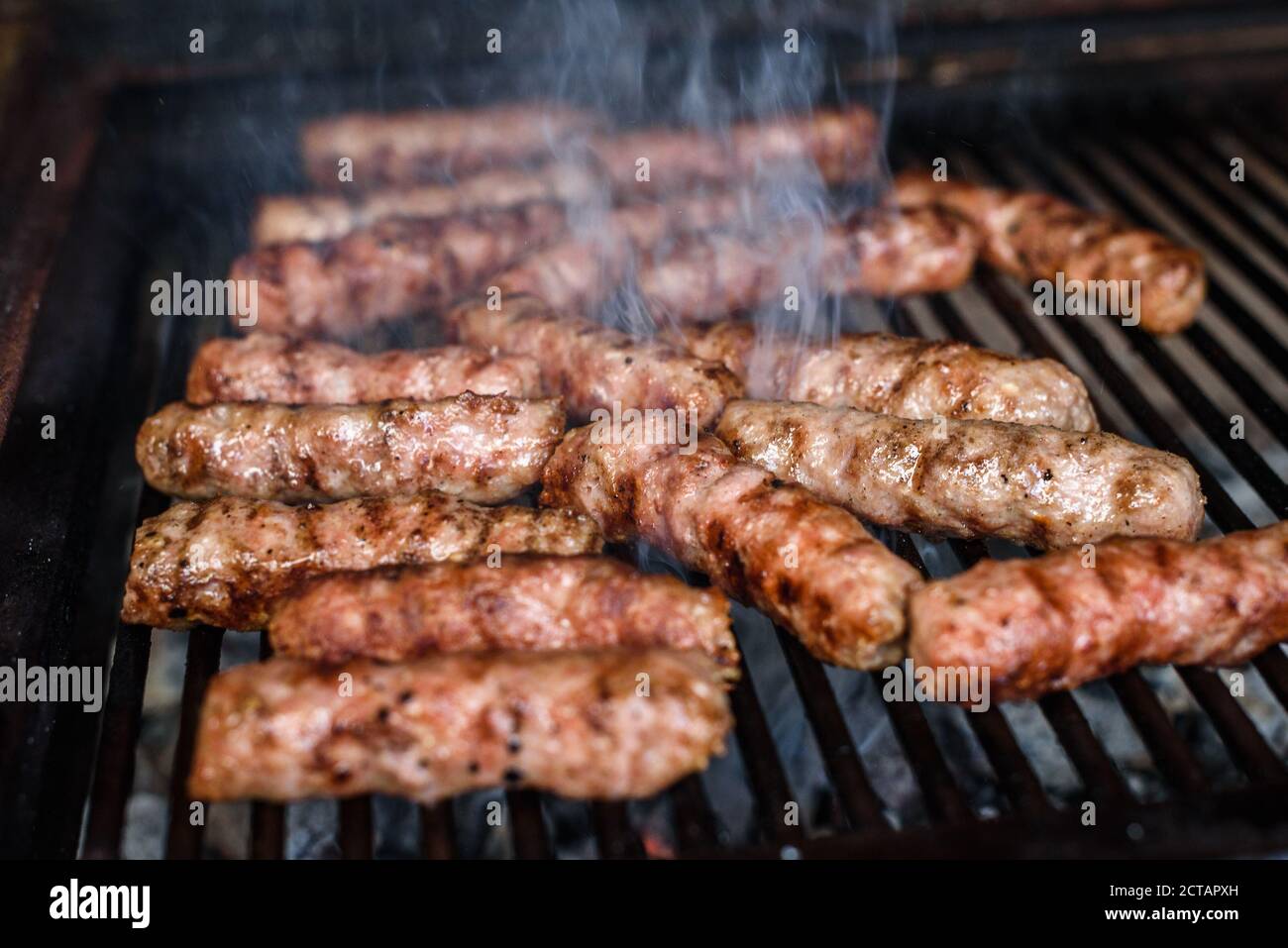Grilling Meat on barbecue grill with hot coal. Preparing, cooking cevapcici,  kebabs, country sausage on charcoal barbecue BBQ in outside fireplace. Tr  Stock Photo - Alamy