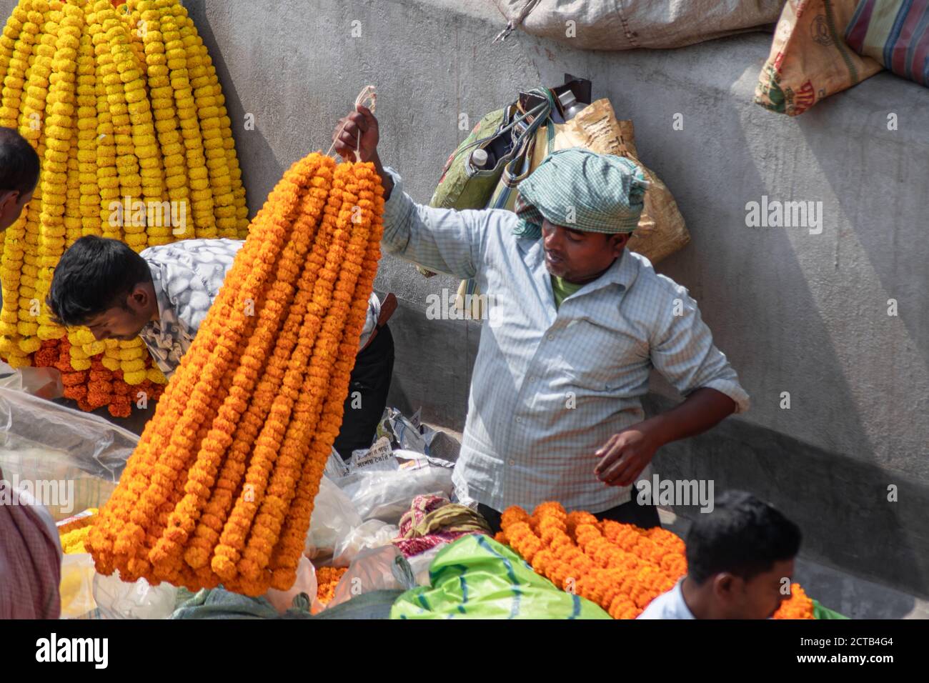 Kolkata, India - February 2, 2020: Unidentified people attends Mallick Ghat flower market by Howrah bridge to buy and sell colorful marigold flowers Stock Photo