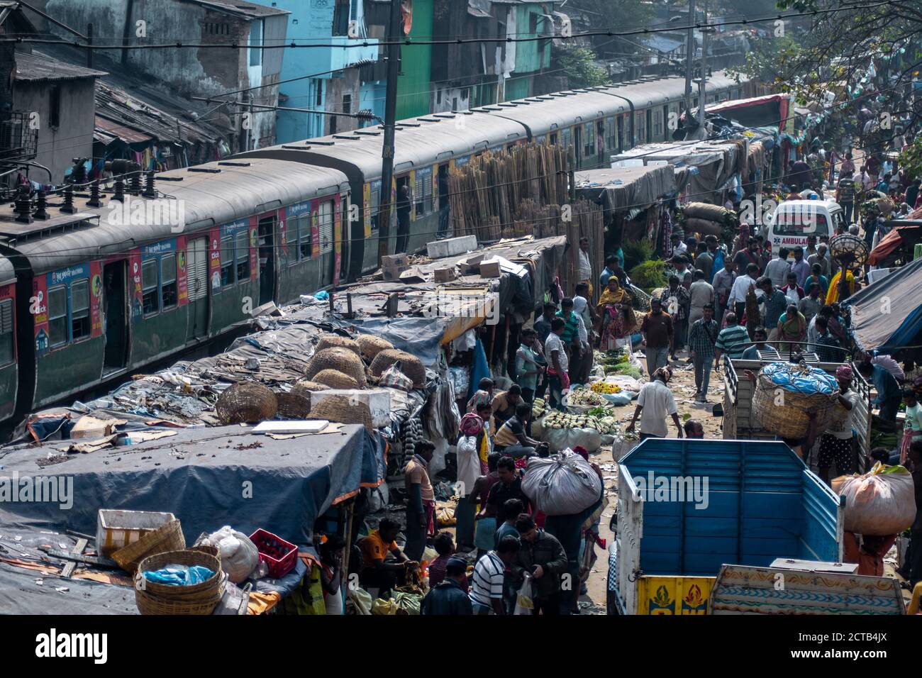 Kolkata, India - February 2, 2020: Unidentified people attends Mallick Ghat flower market by Howrah bridge and a train passes by on February 2, 2020 Stock Photo