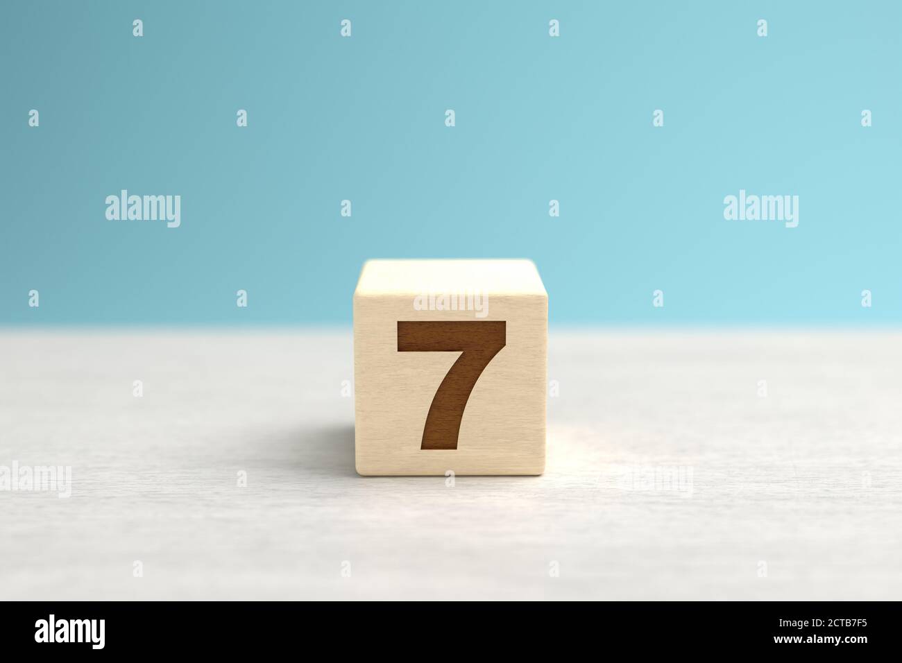 A wooden toy cube with the number 7. Stock Photo