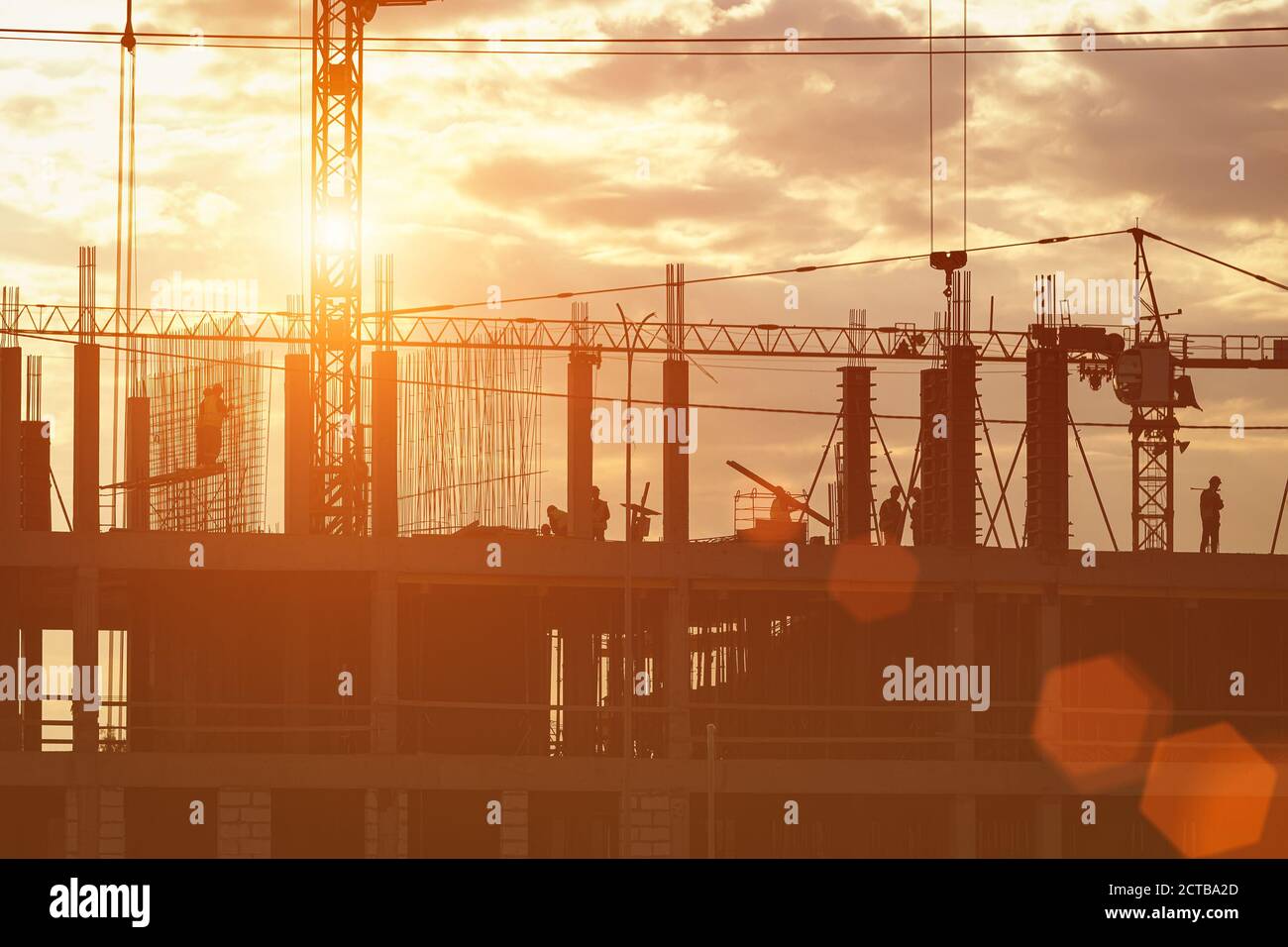 Silhouette of a team of construction workers in and a crane ...