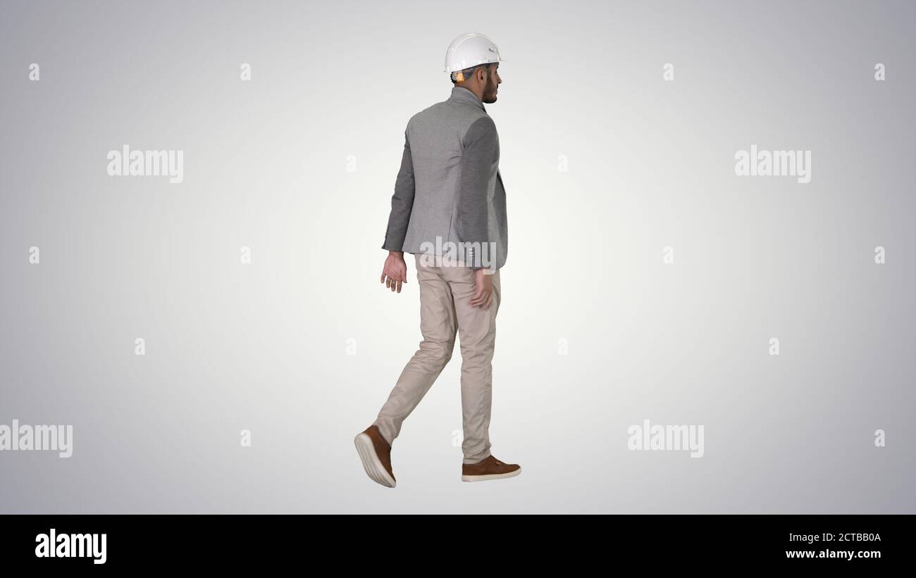 Arabian engineer with hardhat walking Safety concept on gradient Stock Photo