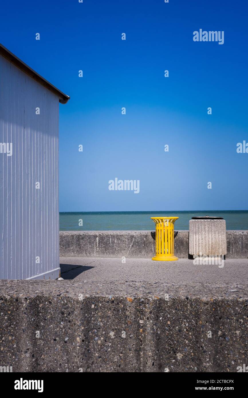 Wooden hut with yellow garbage on the beach in Normandy. Stock Photo