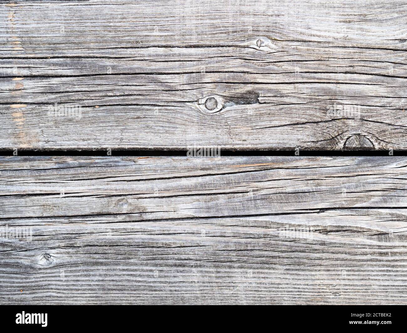 naturally discolored shabby gray wooden planks of outdoor pavement of pier close up Stock Photo