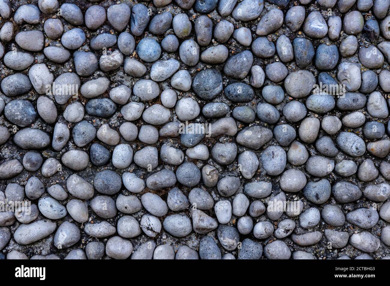 Pebbles in concrete background. Grey color and flat lay Stock Photo