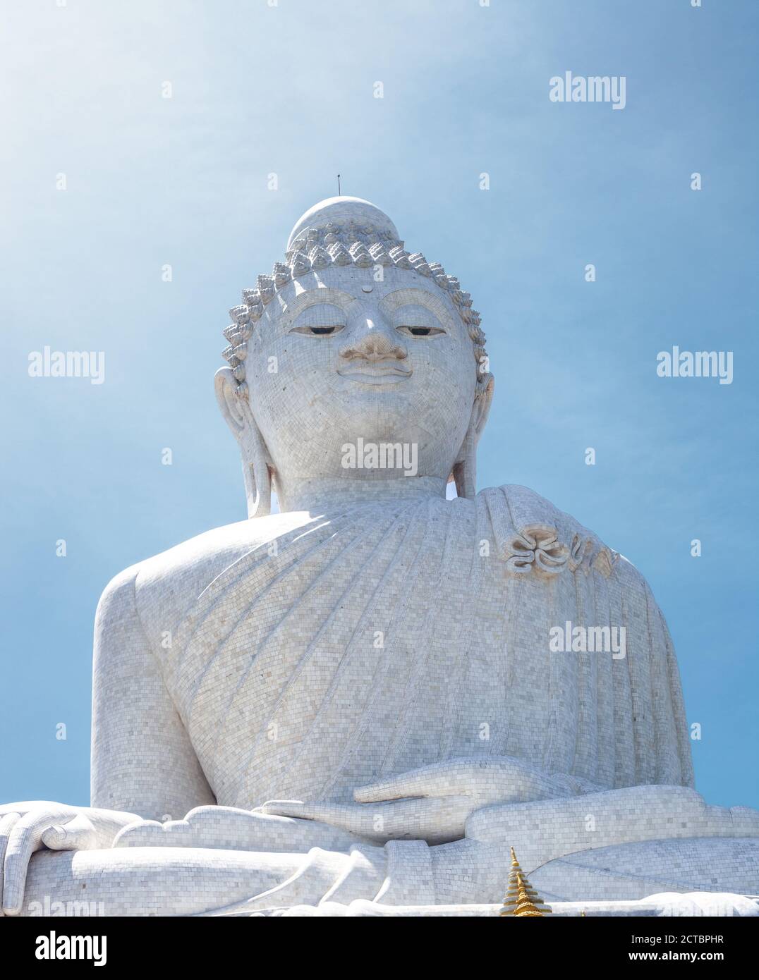 White marble statue of Phuket Big Buddha by blue sunny sky background ...