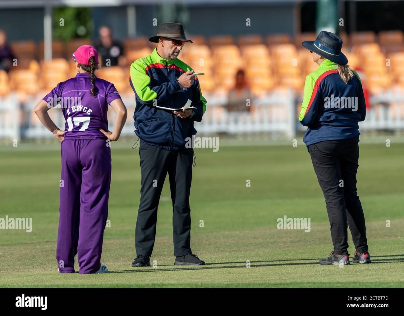 Umpires Paul Pollard and Malinda Underdown discuss awarding Central Sparks penalty runs, watched by Lightning captain Kathryn Bryce Stock Photo