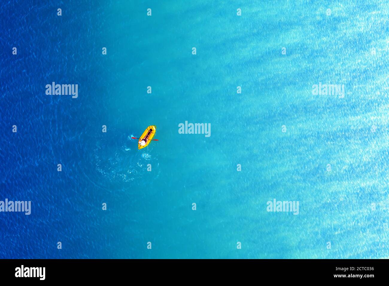Yellow packraft rubber boat and turquoise water waves from top view. Active travel summer vacations seascape background from drone Stock Photo