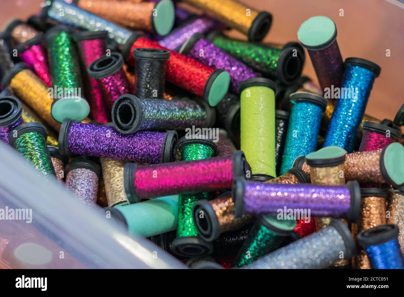 rolls with metallic threads in plastic container  in assortment for craft Stock Photo
