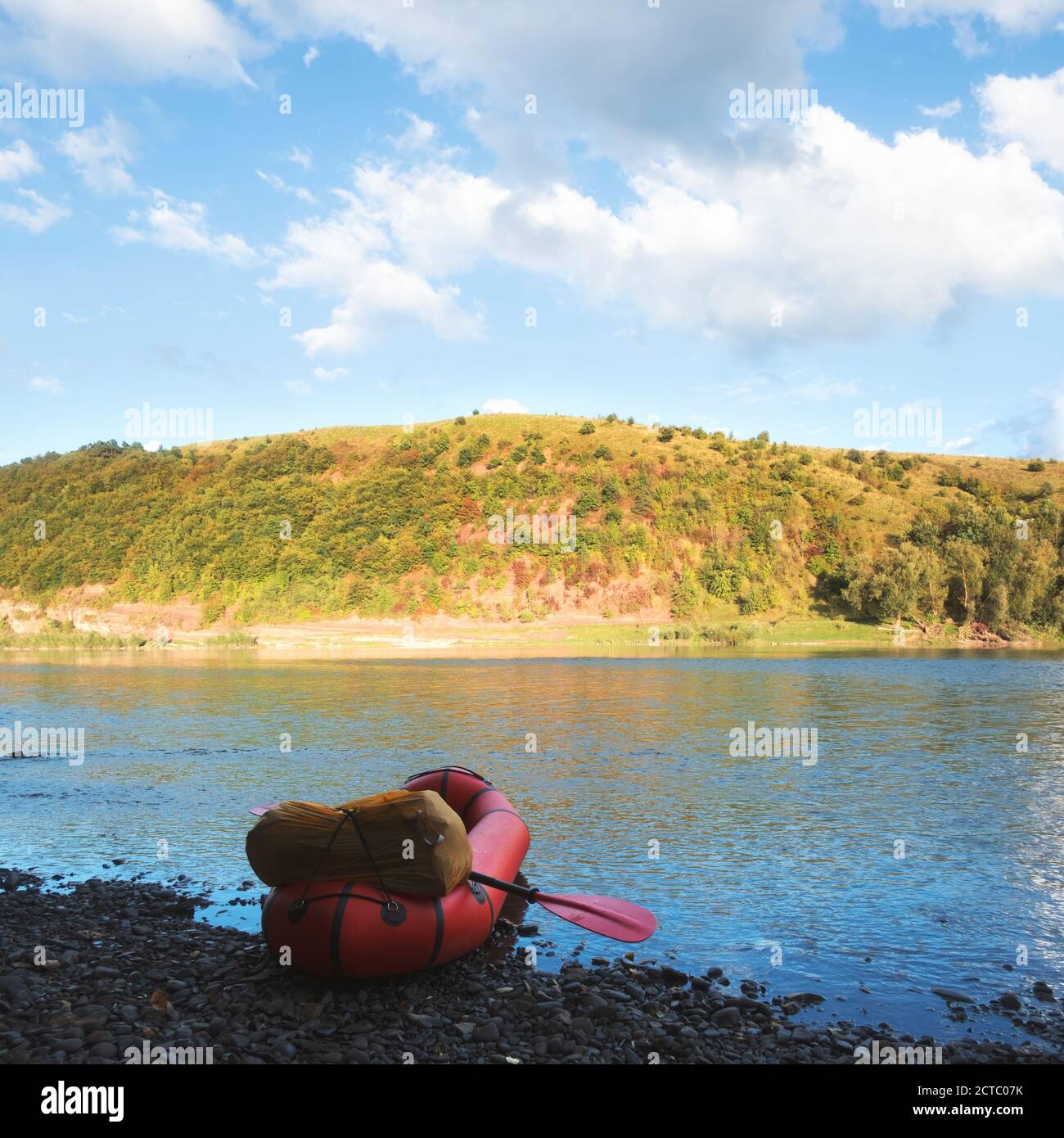 Orange packraft rubber boat with backpack on a river. Packrafting. Active lifestile concept Stock Photo