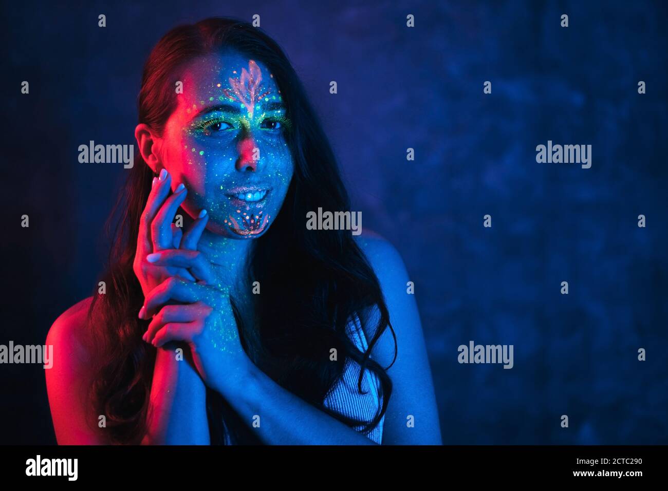Portrait of calm young woman with UV body art. Beautiful fantastic drawing on skin. Stock Photo