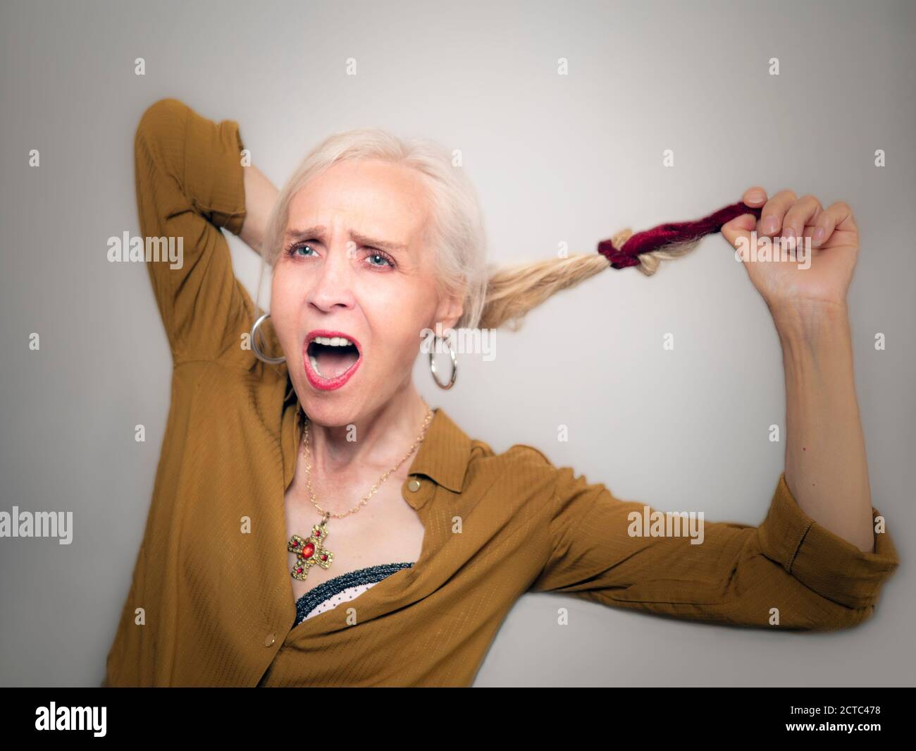horizontal portrait of an elegant beautiful woman shouting while releasing her hair Stock Photo